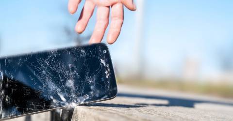 Een mobiele telefoon die op de stenen kapot valt